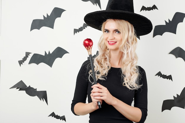 Pretty witch posing with magic wand