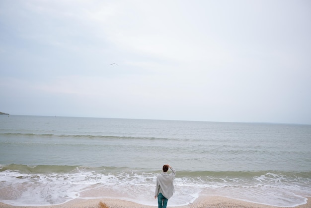 Pretty woman alone by the ocean cloudy weather Happy female relaxing