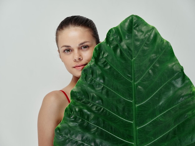 Pretty woman big green leaf cropped view studio