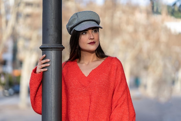 Pretty woman in black and white hat with red sweater