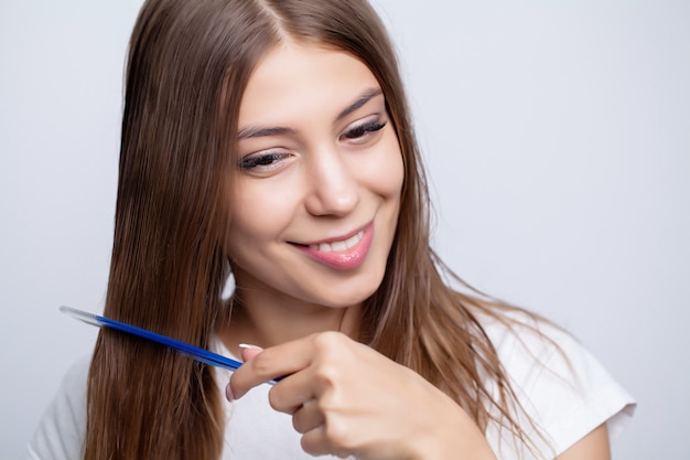 Pretty woman combs her hair at home