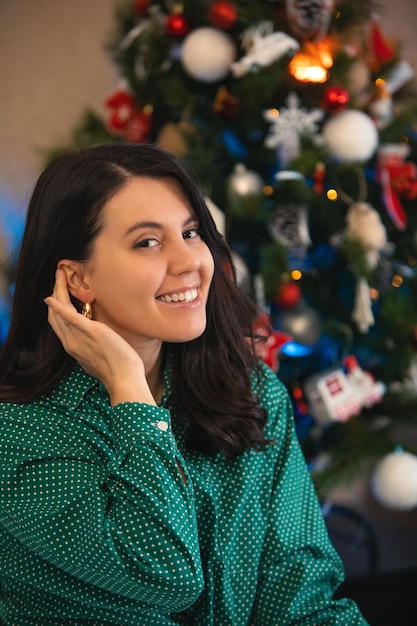 Pretty woman decorating christmas tree at home