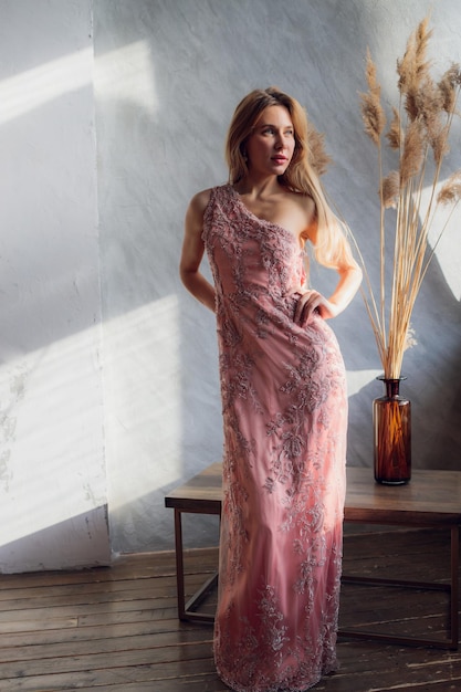 Pretty woman in evening dress with hair style posing near a restaurant bar looking in camera