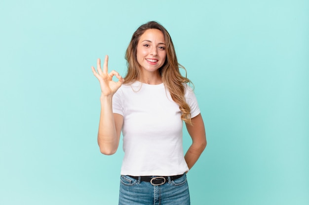 Pretty woman feeling happy, showing approval with okay gesture