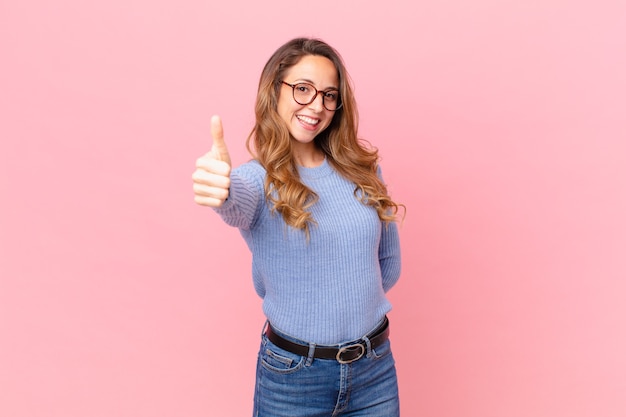 Pretty woman feeling proud,smiling positively with thumbs up