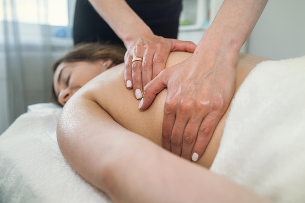 Pretty woman having back massage in spa