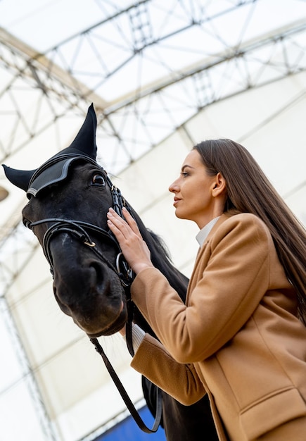 Pretty woman jockey with horse Attractive female model posing with horse