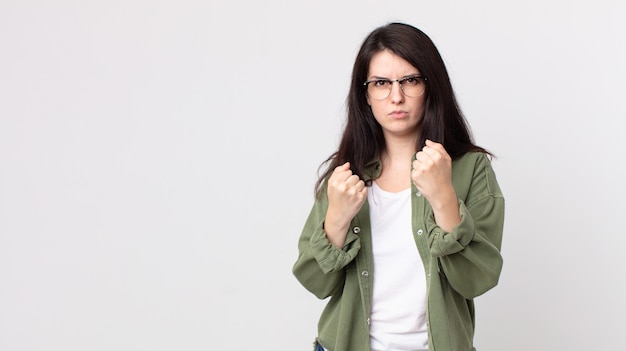 Pretty woman looking confident, angry, strong and aggressive, with fists ready to fight in boxing position