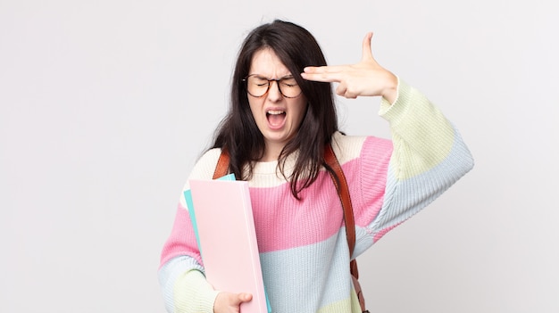 Pretty woman looking unhappy and stressed, suicide gesture making gun sign. university student concept