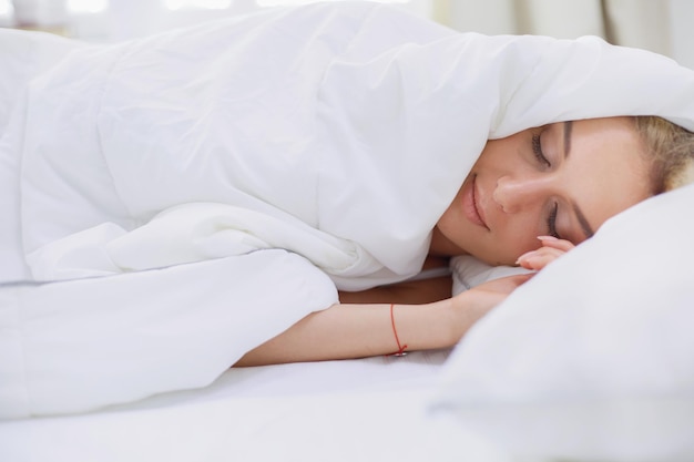 Pretty woman lying down on her bed at home