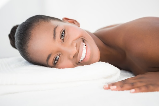 Pretty woman lying on massage table smiling at the camera