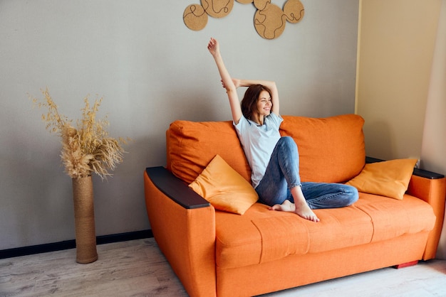 Pretty woman on the orange couch in the rest room posing unaltered