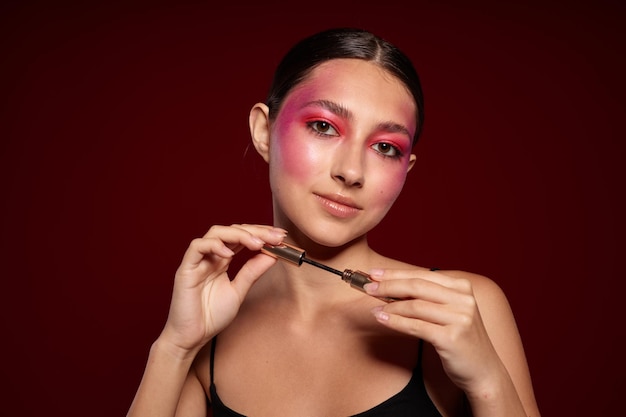 Pretty woman pink face makeup posing attractive look skin care pink background unaltered