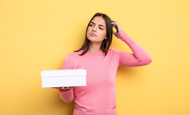 pretty woman smiling happily and daydreaming or doubting. white box packaging concept