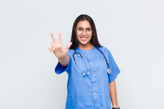 Pretty woman smiling and looking friendly, showing number three or third with hand forward, counting down