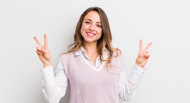 Pretty woman smiling and looking happy friendly and satisfied gesturing victory or peace with both hands