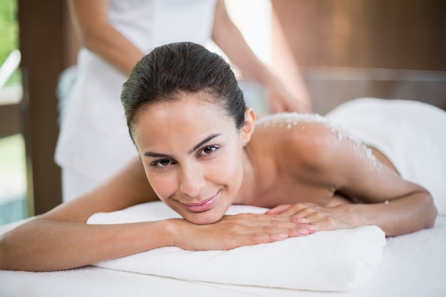 Pretty woman smiling while receiving spa treatment