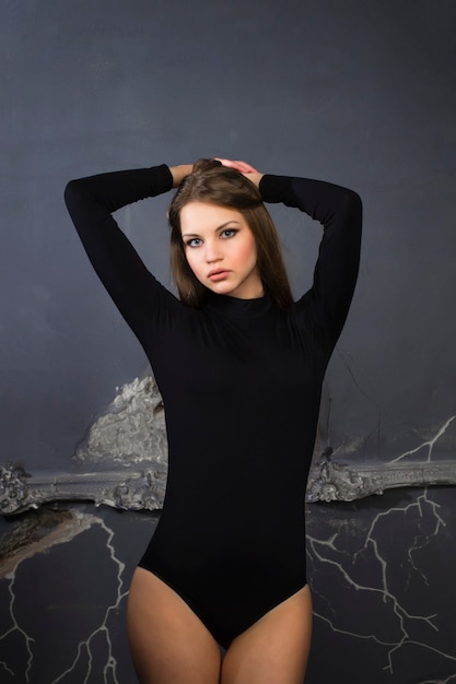 Pretty woman standing at the broken wall. Studio shot