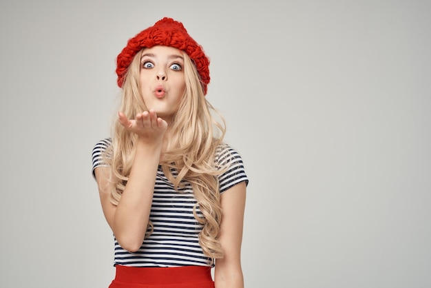 Pretty woman in a striped Tshirt Red Hat light background Lifestyle