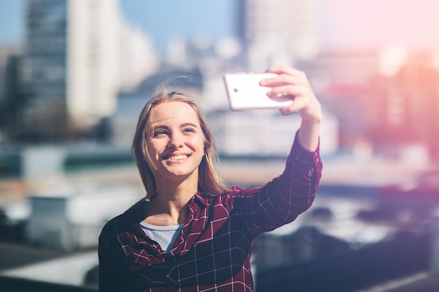 Pretty woman taking a selfie. Beautiful girl walking on the streets and photographing some landmarks. Blonde taken pictures of her self, instagram