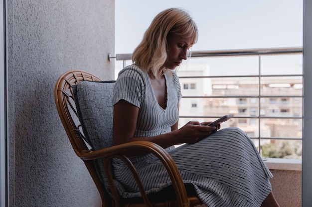 A pretty woman talks on the phone on the sunny terrace