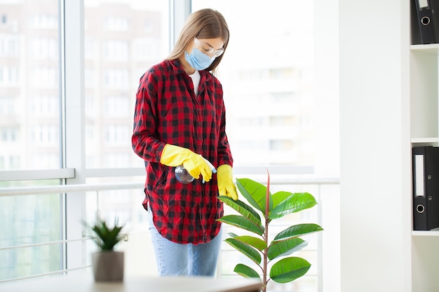 Pretty woman in uniform with supplies cleaning in office.