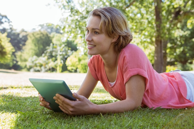 Pretty woman using tablet in park