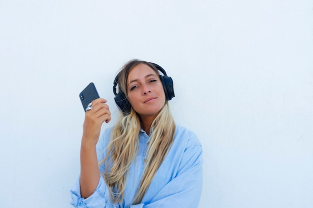 Pretty woman with phone in hand listening to music