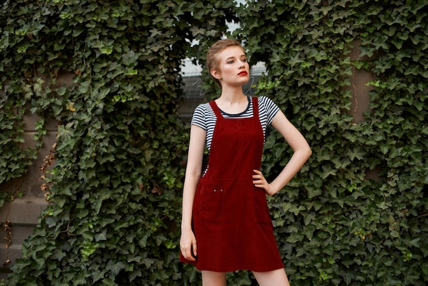 Photo pretty woman with short hair outdoors on a background of bushes