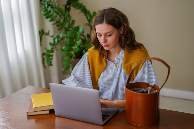 Pretty woman working at her home office, smiling end enjoying time at her living room.