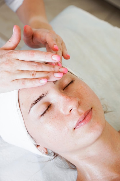 Pretty yanog woman receiving face massage closeup photo