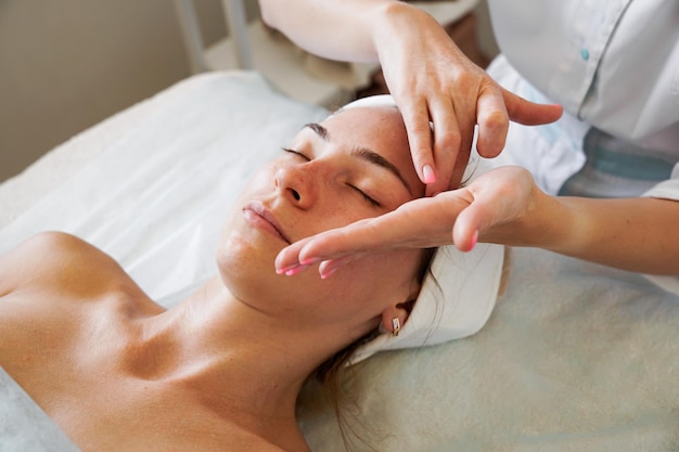 Pretty yanog woman receiving face massage closeup photo