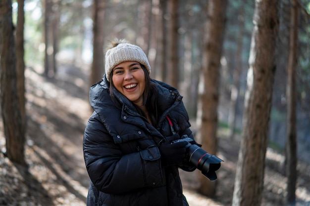 Pretty young girl bundled up in a forest in the mountains