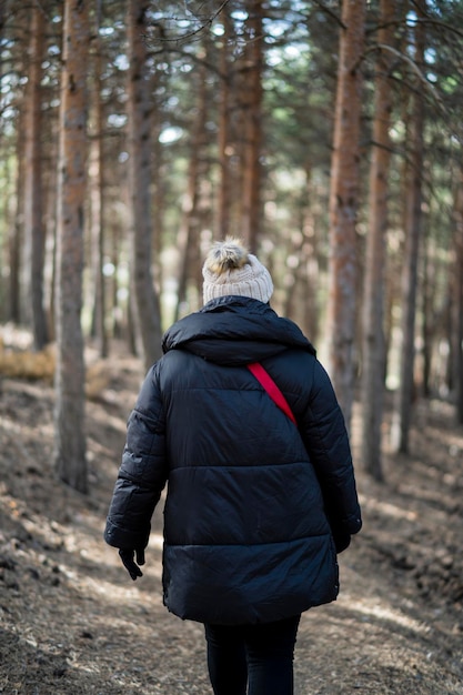 Pretty young girl bundled up in a forest in the mountains