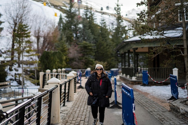 Pretty young girl bundled up in ski village smiling