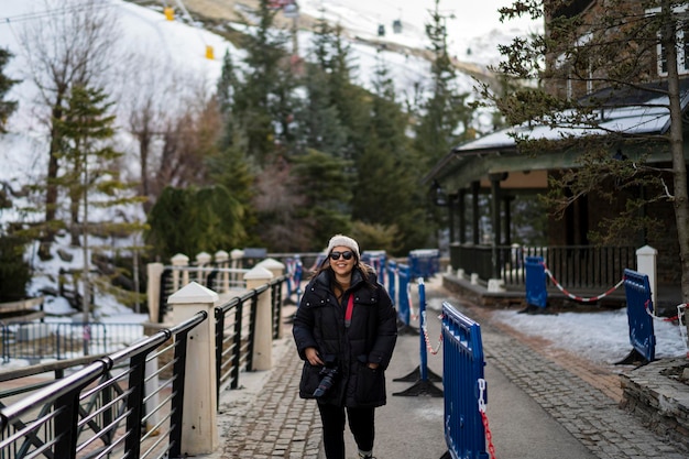 Pretty young girl bundled up in ski village smiling