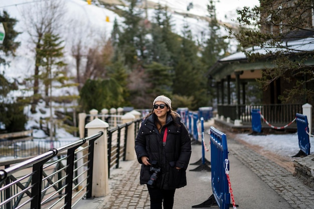 Pretty young girl bundled up in ski village smiling