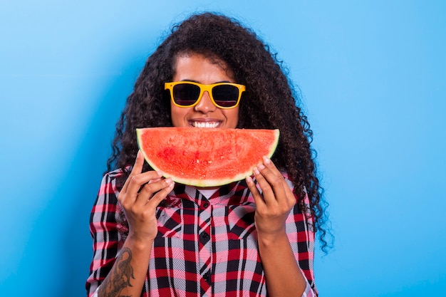 Pretty young girl holding slice of watermelon in front of her face. Portrait of smiling african american girl isolated   Healthy & Happy  