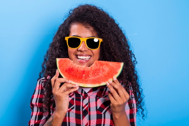 Pretty young girl holding slice of watermelon in front of her face. Portrait of smiling african american girl isolated   Healthy & Happy  