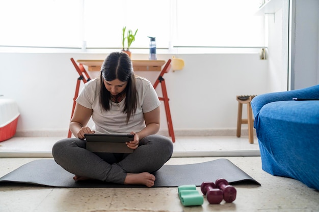 pretty young girl practicing exercise and yoga in her living room with a black cat