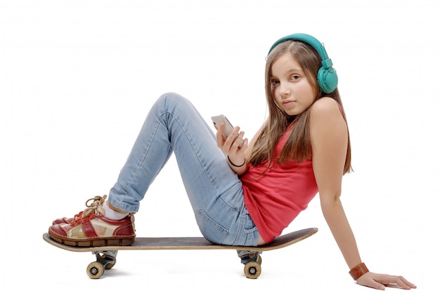 Pretty young girl sitting on skate, listen  music