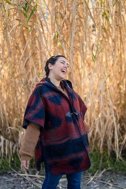 pretty young girl smiling and posing in front of some branches in the field