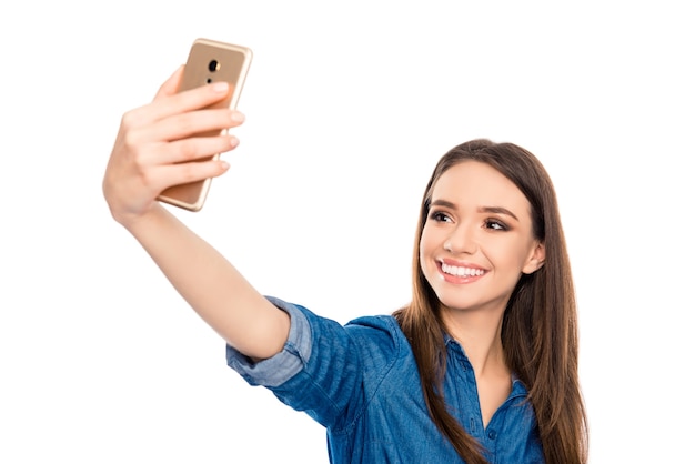 Pretty young happy woman making selfie on smartphone