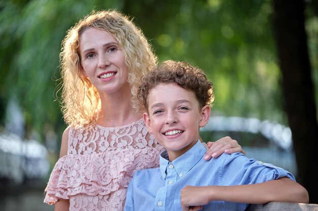 Pretty young mother with her son enjoying time together in summer park. Happy family leasure activity concept