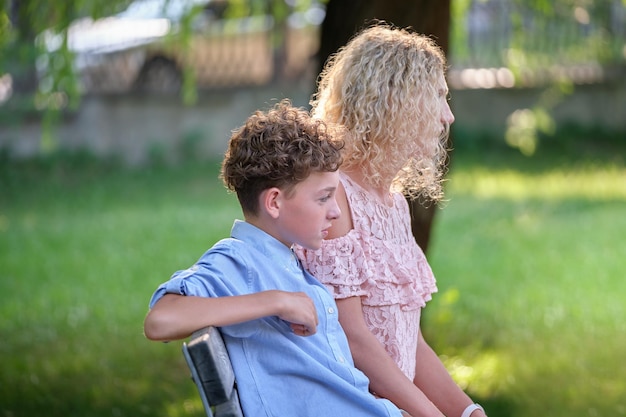 Pretty young mother with her son enjoying time together in summer park Happy family leasure activity concept