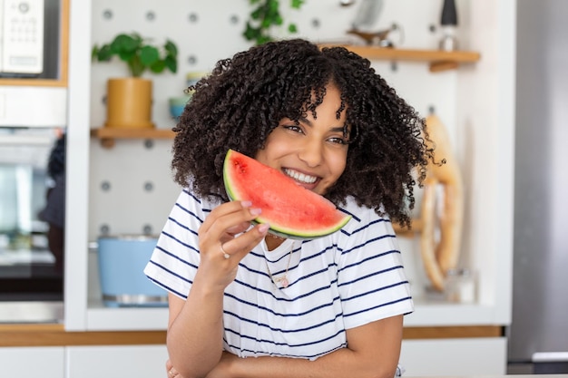 Pretty young smiling woman eating watermelon woman holding watermelon slice