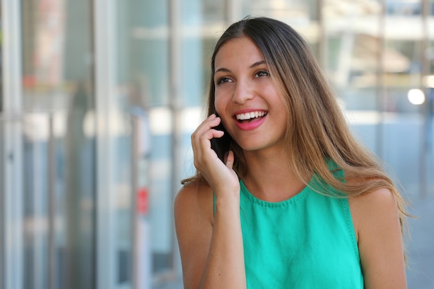 Pretty young woman calling with smart phone outdoor