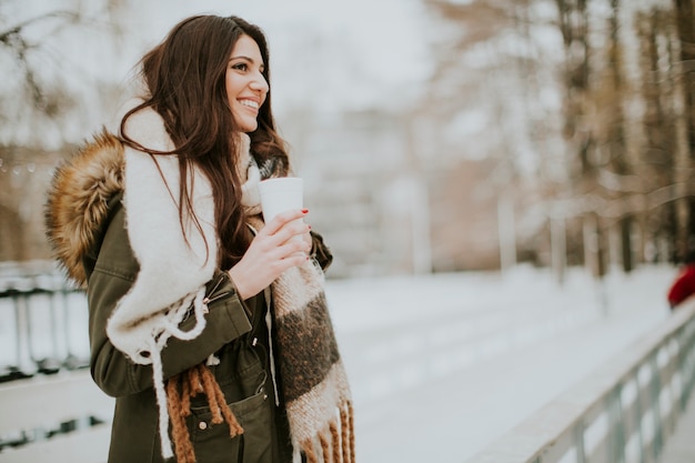 Pretty young woman drinking hot tea on a cold winter day