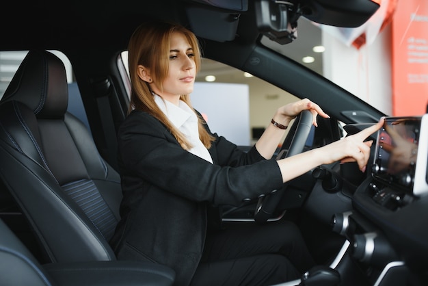 Pretty young woman driving her new car (color toned image; shallow DOF)