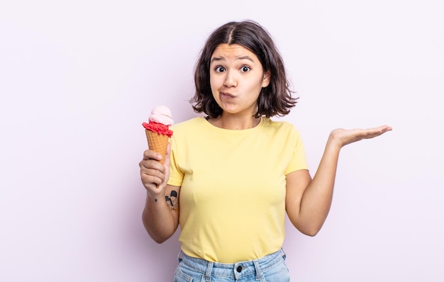 Pretty young woman feeling puzzled and confused and doubting. ice cream concept